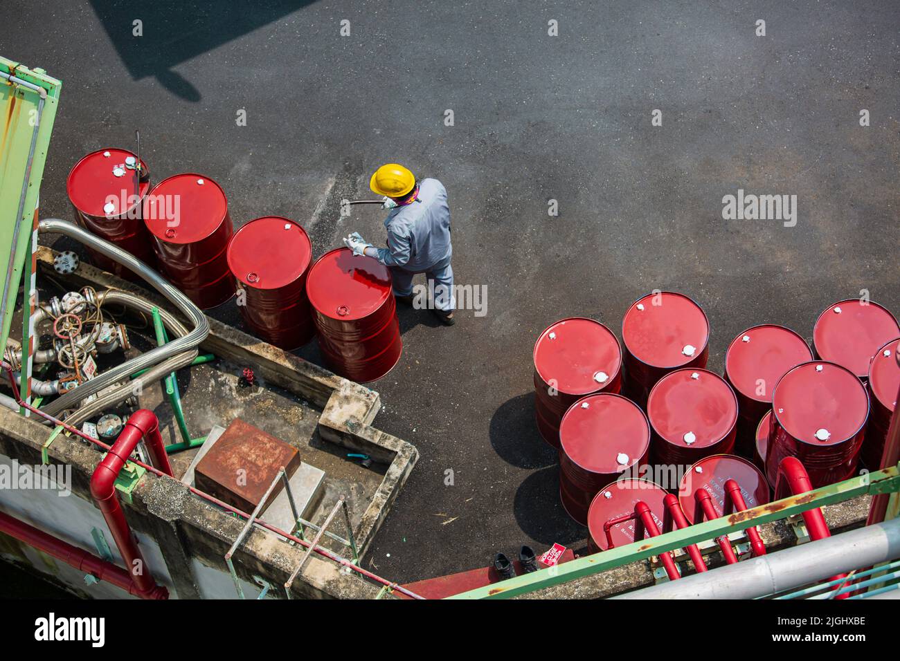 Draufsicht männliche Arbeiter Inspektionsaufzeichnung Fass Ölvorrat Fässer rot vertikal oder Chemikalien für in der Industrie. Stockfoto