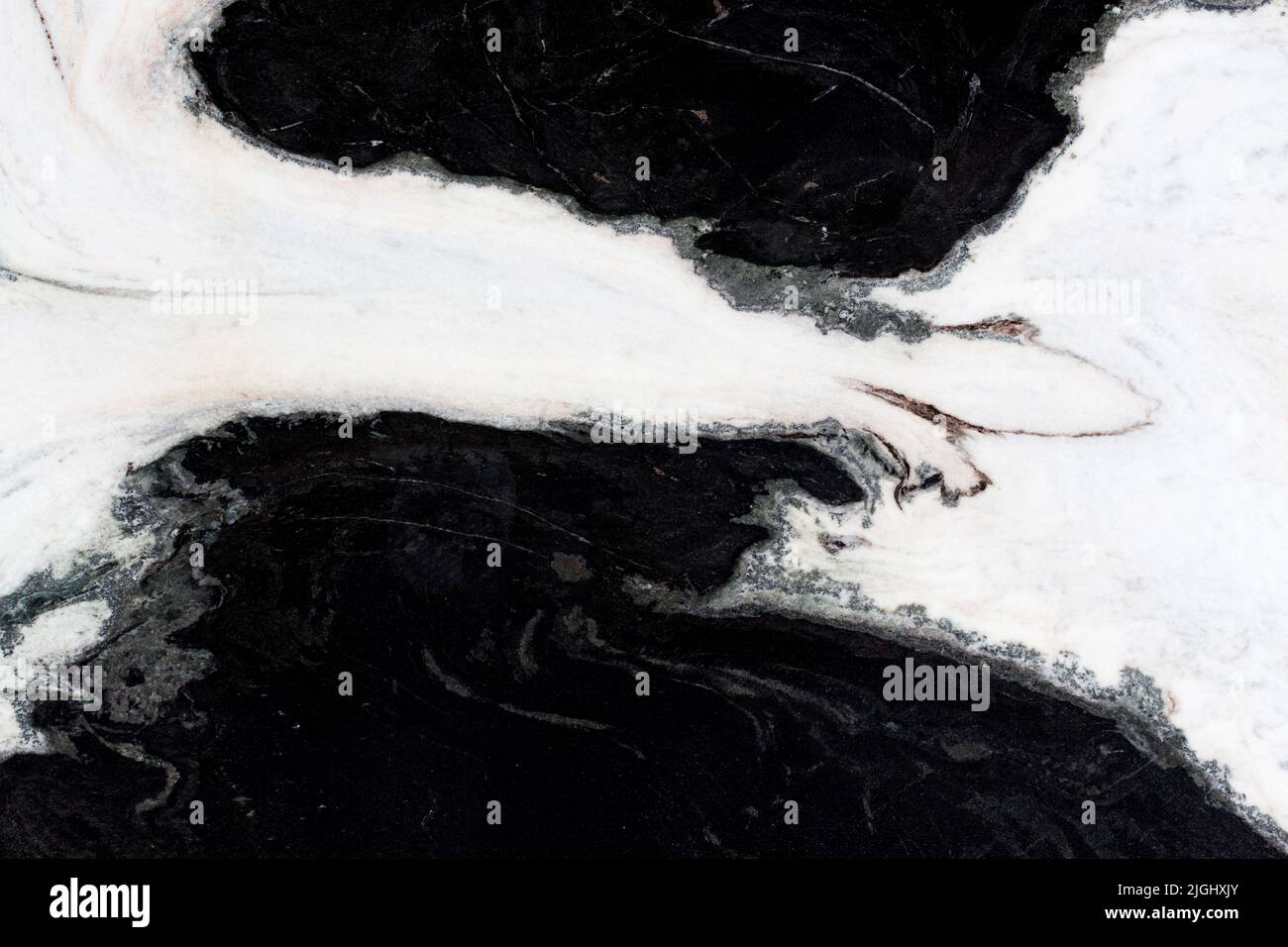 Weißer Naturmarmor mit kontrastierenden schwarzen Punkten. Stockfoto