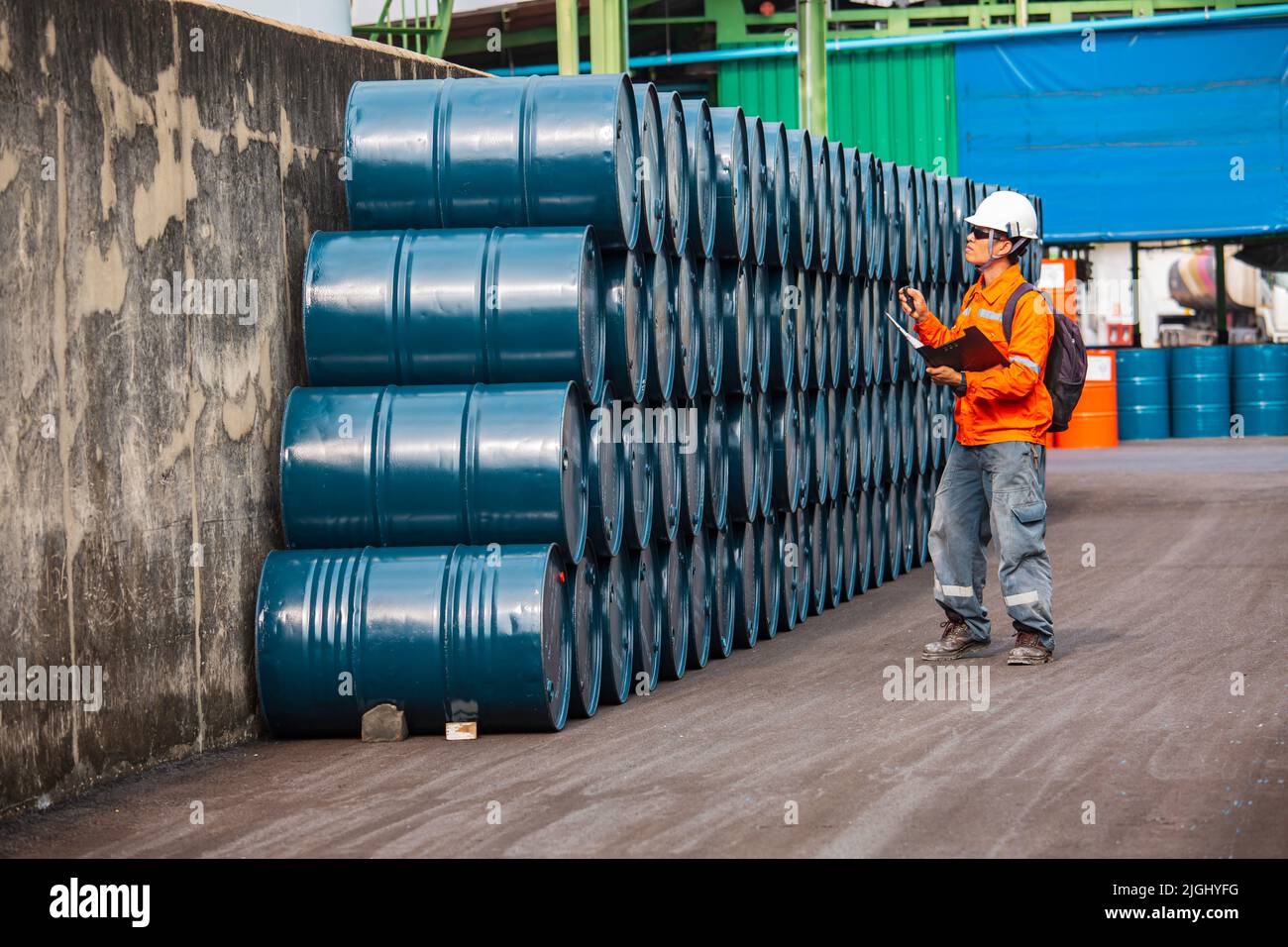 Männliche Arbeiter Inspektion Rekord Fass Öl Lager Fässer blau horizontal oder chemisch für in der Industrie. Stockfoto