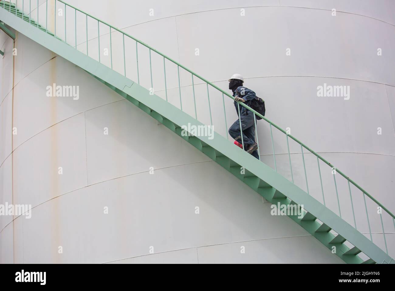 Mann, der die Treppenaufgänge überprüft, Sichtlagerbehälter, Chemikalie. Stockfoto