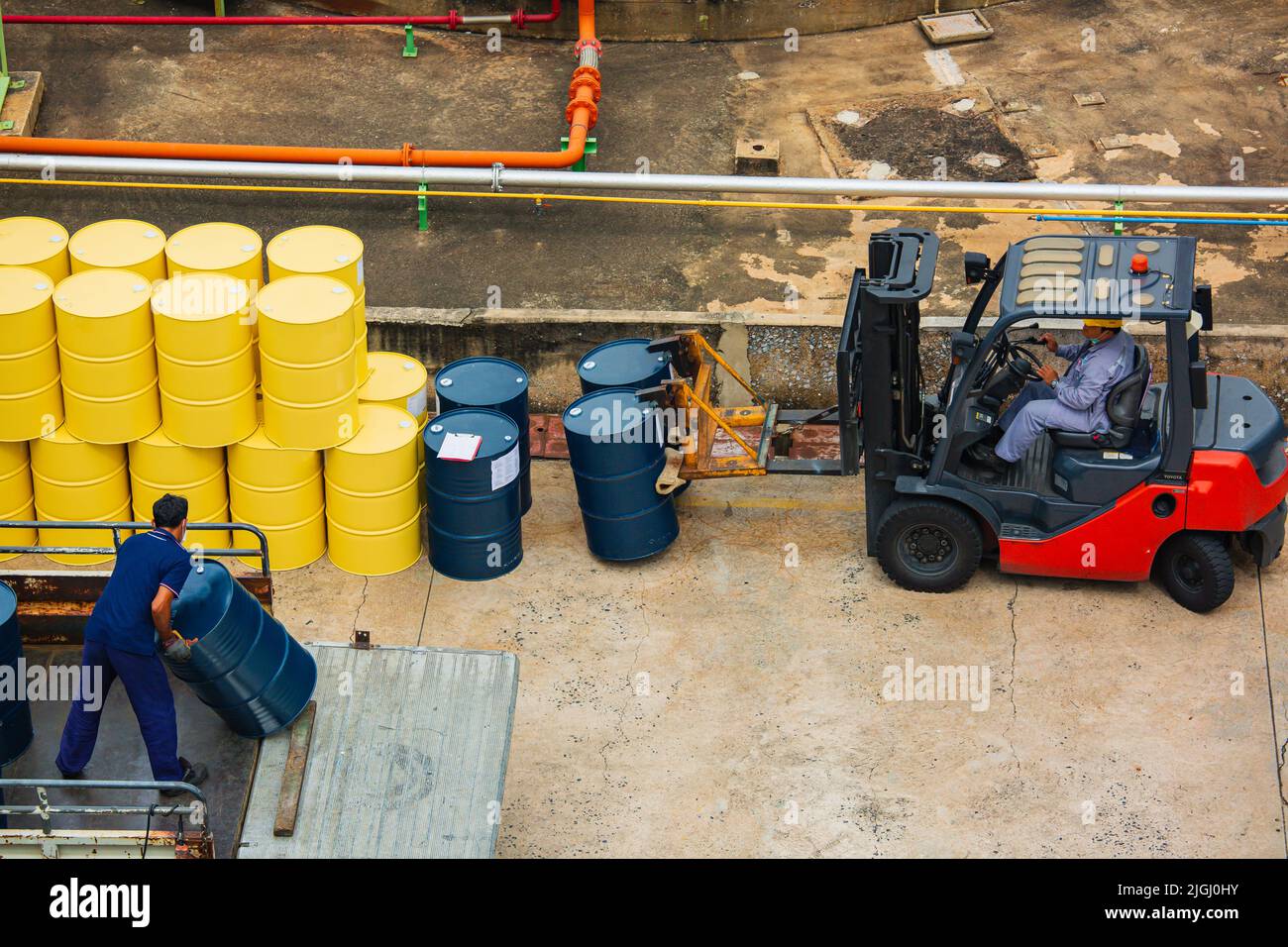 Draufsicht Ölfässer Gabelstapler bewegen für auf dem Transport LKW männliche Arbeiter helfen zu arrangieren. Stockfoto