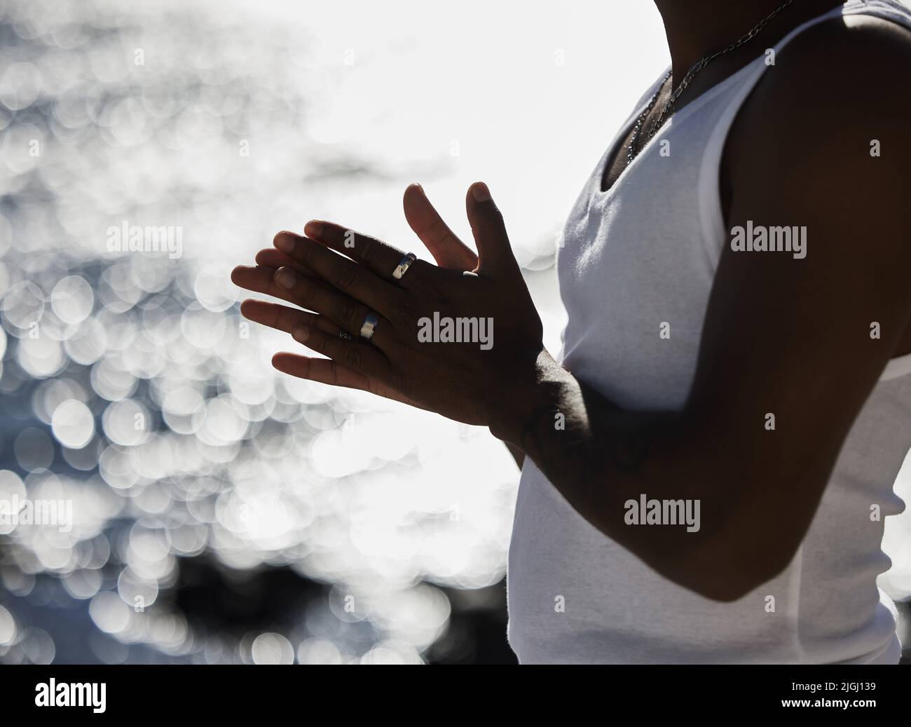 Die wichtigste Person, der Sie vertrauen sollten, ist Sie selbst. ein unkennbarer Mann reibt seinen hans vor einem Küstenhintergrund zusammen. Stockfoto