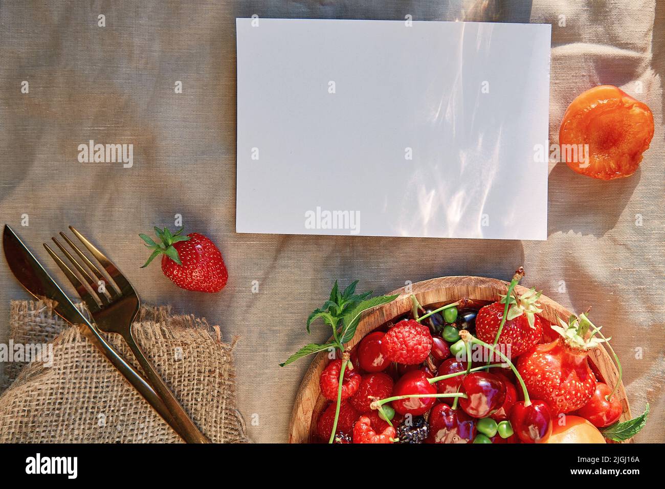 Sommer rustikale Schreibwaren Karte Mockup mit harten Schatten, Sonnenlicht und frischen Früchten der Saison, Beeren. Draufsicht, flach liegend. Stockfoto