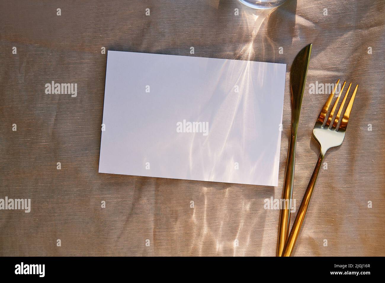 Minimalistische Schreibwarenkarte mit harten Schatten, Sonnenlicht und Besteck. Draufsicht, Kopierbereich. Menügestaltung, Postkarte, Einladungsmockup. Stockfoto