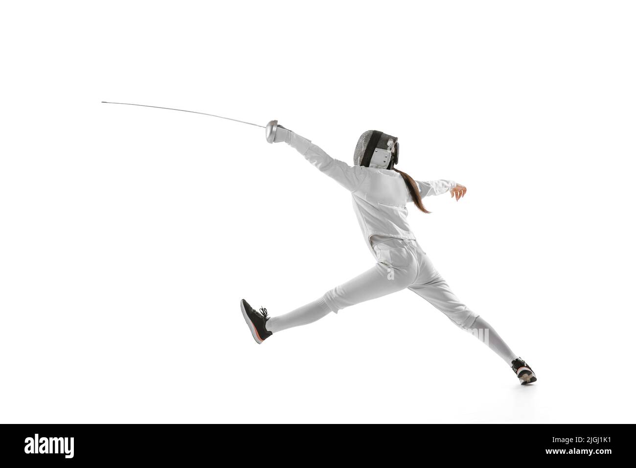 Eine Sporterin, weibliche Fechterin in weißem Fechtkostüm in Aktion, Bewegung isoliert auf weißem Hintergrund. Sport, Jugend, Hobbys, Erfolge, Ziel. Stockfoto
