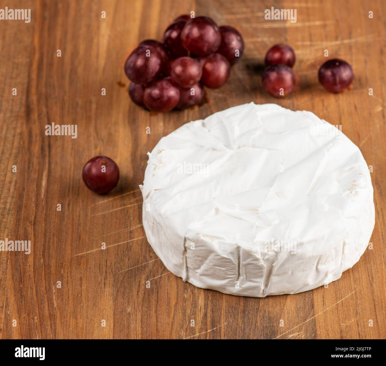 Brie-Käse und Trauben auf einem Schneidbrett Stockfoto