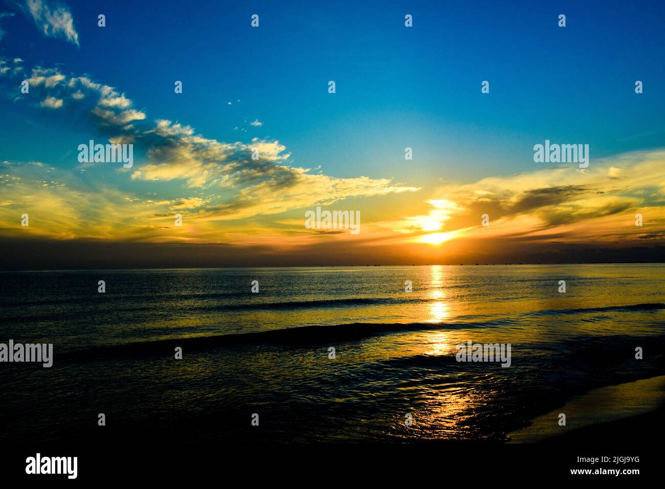 Blick auf den Sonnenaufgang von einem Strand auf einer tropischen Insel in Südostasien Stockfoto