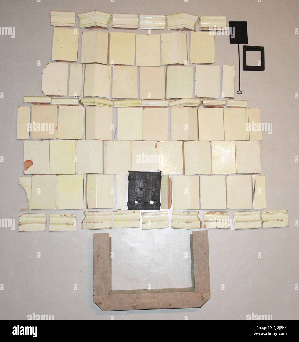 Kakelugn Kachelofen, Sengustavian, auf Holzfüßen gelb glasiert mit Eisenluken. Bestehend aus: 25 ganzen Blattfliese, 8 Halbblattfliese, 10 Eckblattkuchen, 8 mittleren Schwimmfliesen für Regal/Nische, 9 Sockelstapel, 6 Chroniken, Dämpfer, Luke und Fußständer aus Holz. Immobiliengeschenk 3/3 1954 von Baumeister R. Strigård.Negativ-Nr: A 1599 Stockfoto