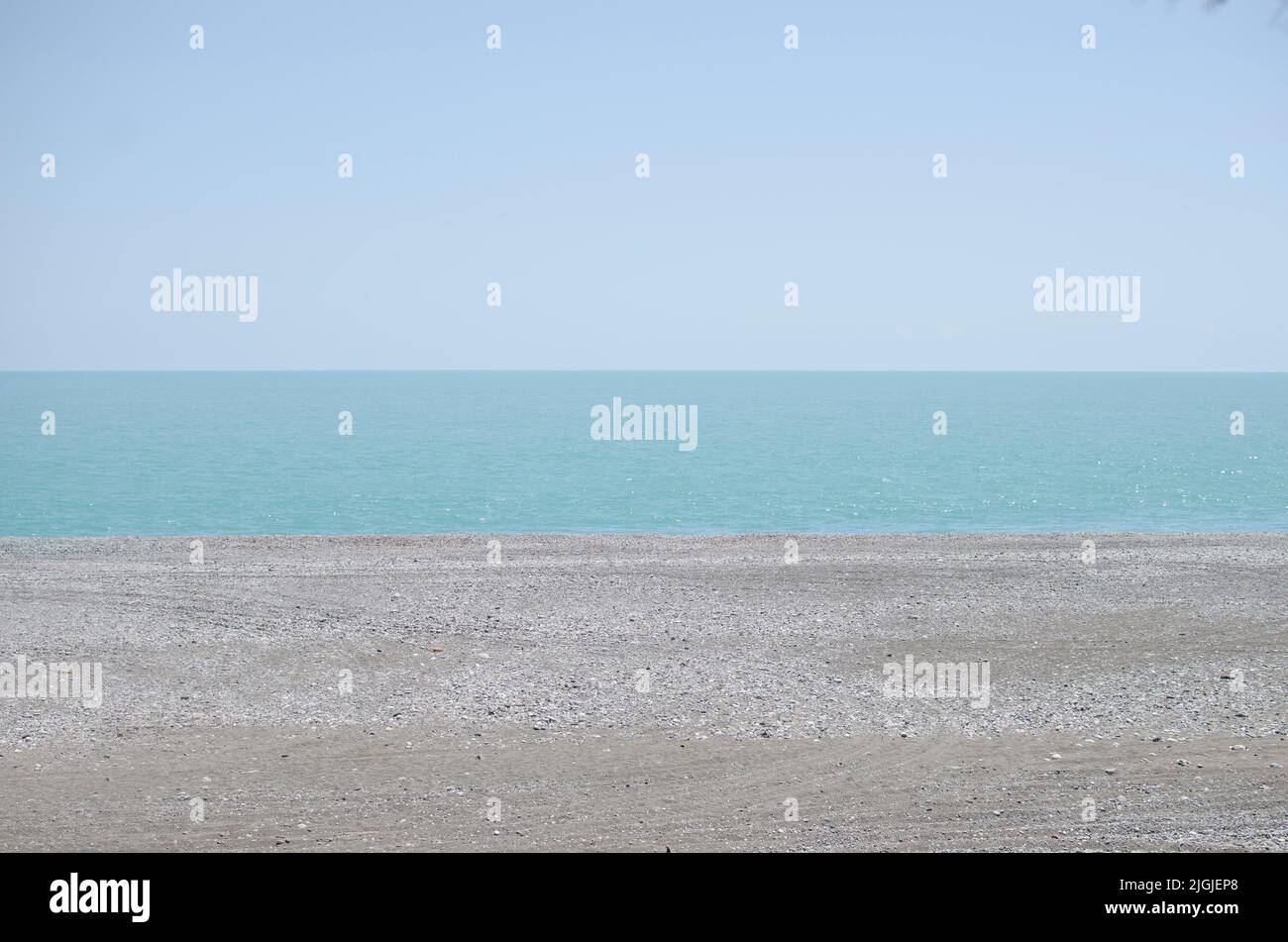 Himmel, Meer und Sand mit Kieselsteinen als Hintergrund. Naturlandschaft Blick auf einen schönen tropischen Strand und Meer an einem sonnigen Tag. Strand am Meer. Panorama Stockfoto