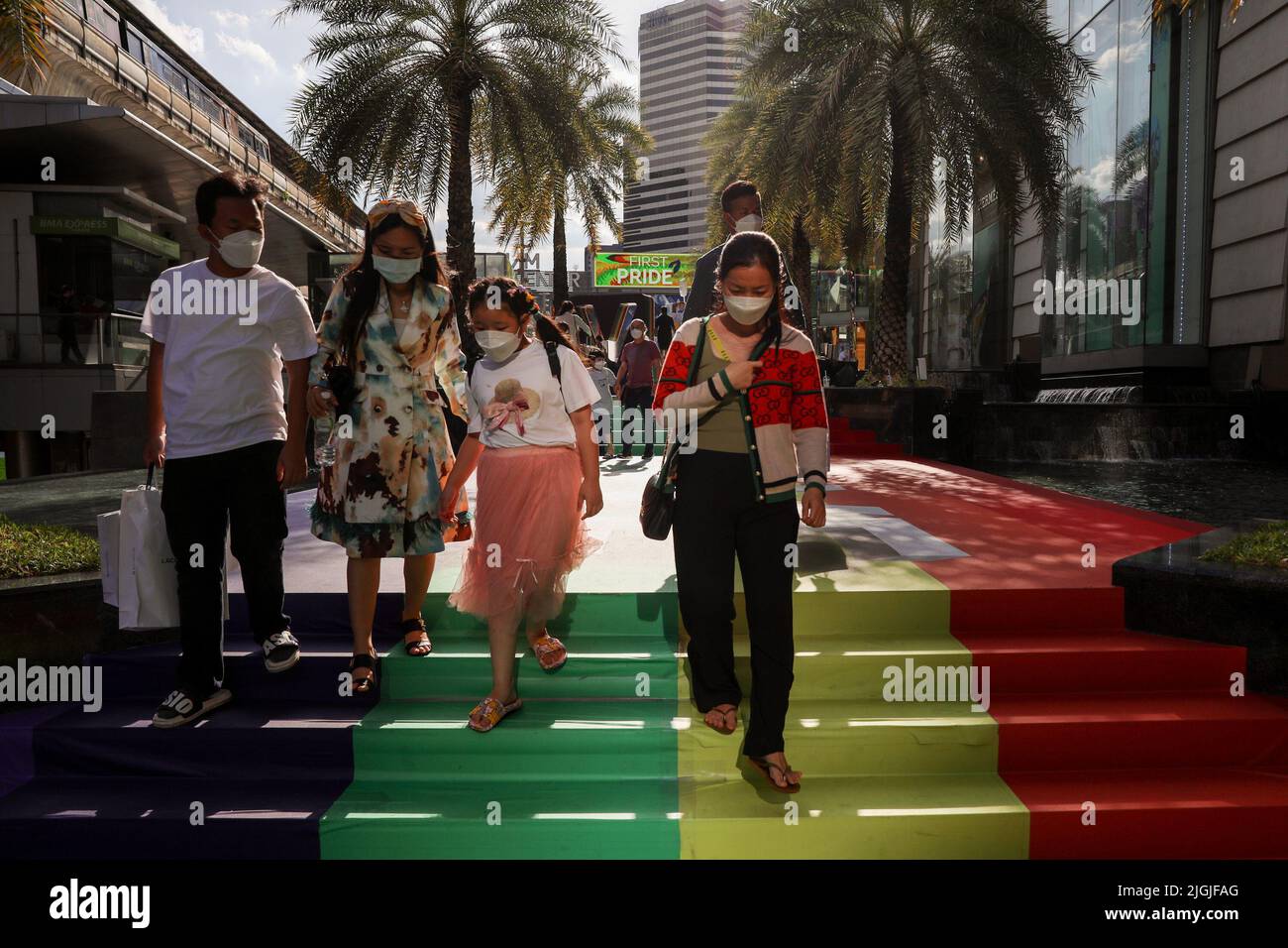 Fußgänger laufen auf einer Regenbogenbahn vor dem Siam Center in Bangkok. Die Gesetzgeber in Thailand gaben der Legalisierung gleichgeschlechtlicher Gewerkschaften erste Zustimmung, ein Schritt näher, um das zweite Gebiet in Asien zu werden, das gleichgeschlechtliche Ehen legalisiert. Thailand. Stockfoto