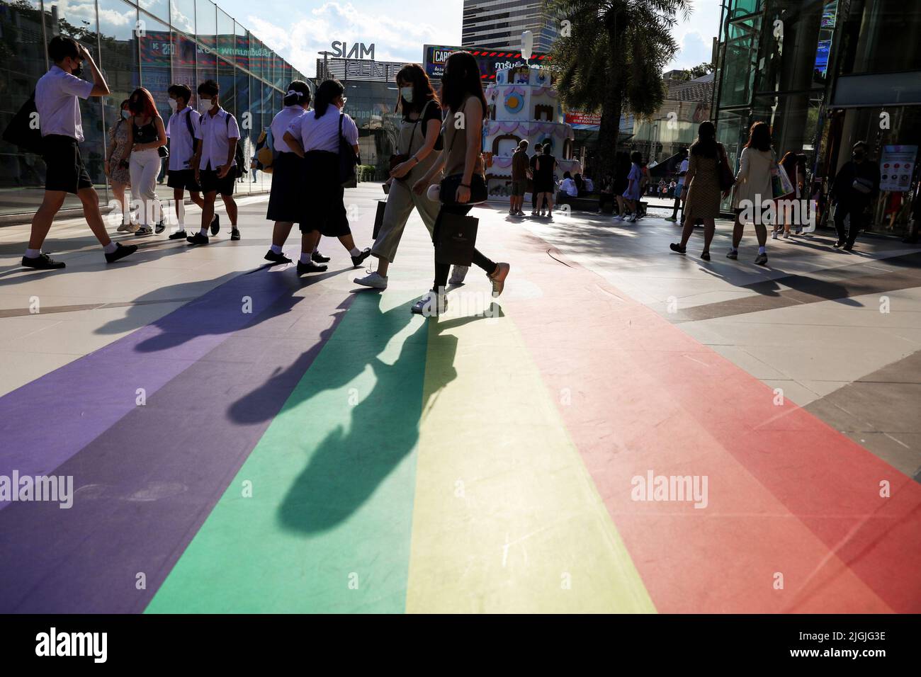 Fußgänger laufen auf einer Regenbogenbahn vor dem Siam Center in Bangkok. Die Gesetzgeber in Thailand gaben der Legalisierung gleichgeschlechtlicher Gewerkschaften erste Zustimmung, ein Schritt näher, um das zweite Gebiet in Asien zu werden, das gleichgeschlechtliche Ehen legalisiert. Thailand. Stockfoto