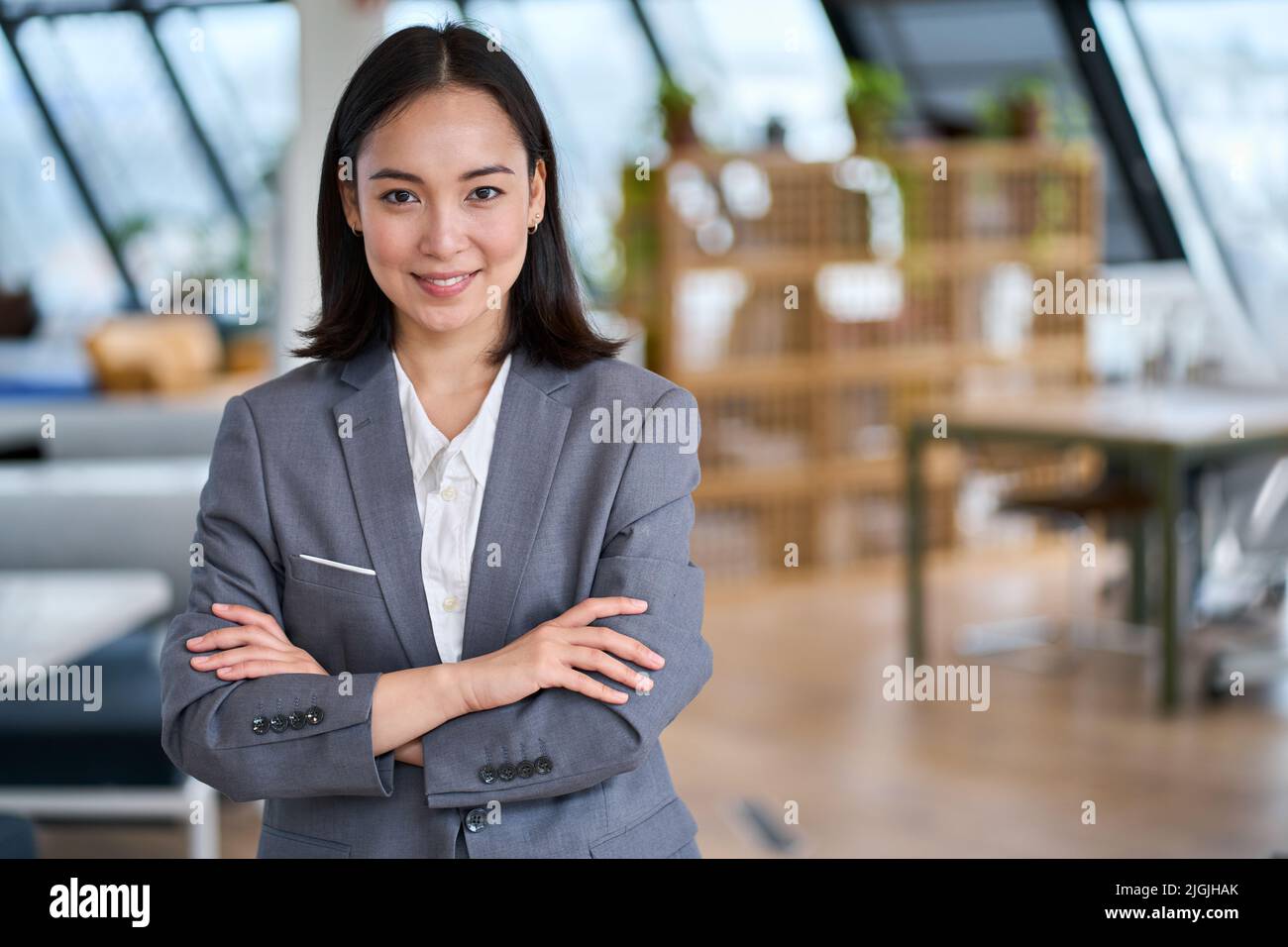 Junge selbstbewusste asiatische Geschäftsfrau im Büro stehend, Porträt. Stockfoto