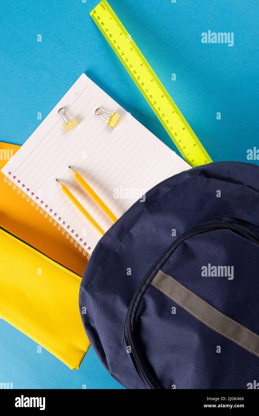 Bild von Schulmaterial, Notizbuch, Rucksack, Lineal, Büroklammern auf blauem Hintergrund Stockfoto