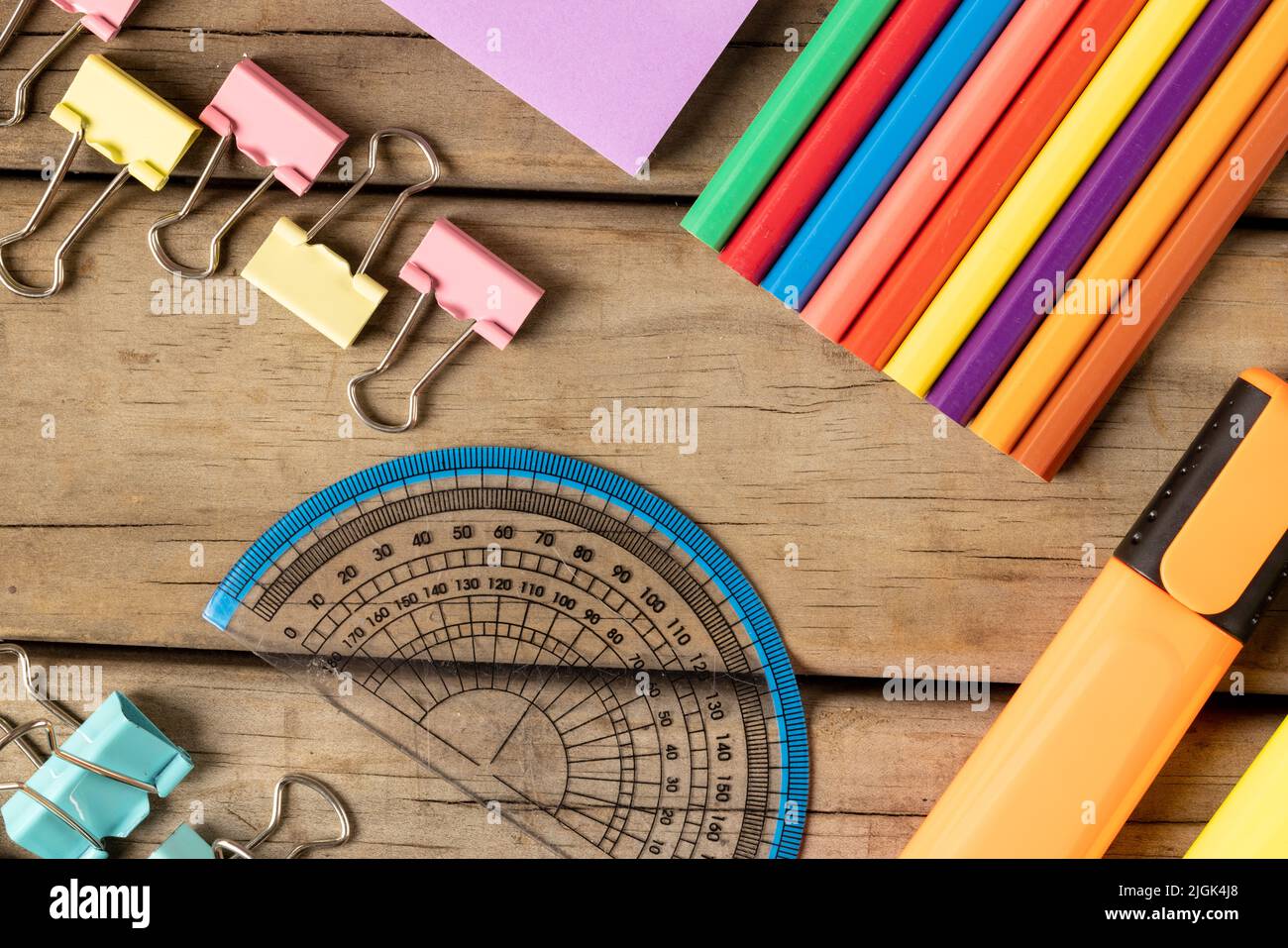 Komposition aus bunten Buntstiften, Stiften und Winkelmesser auf Holzhintergrund Stockfoto