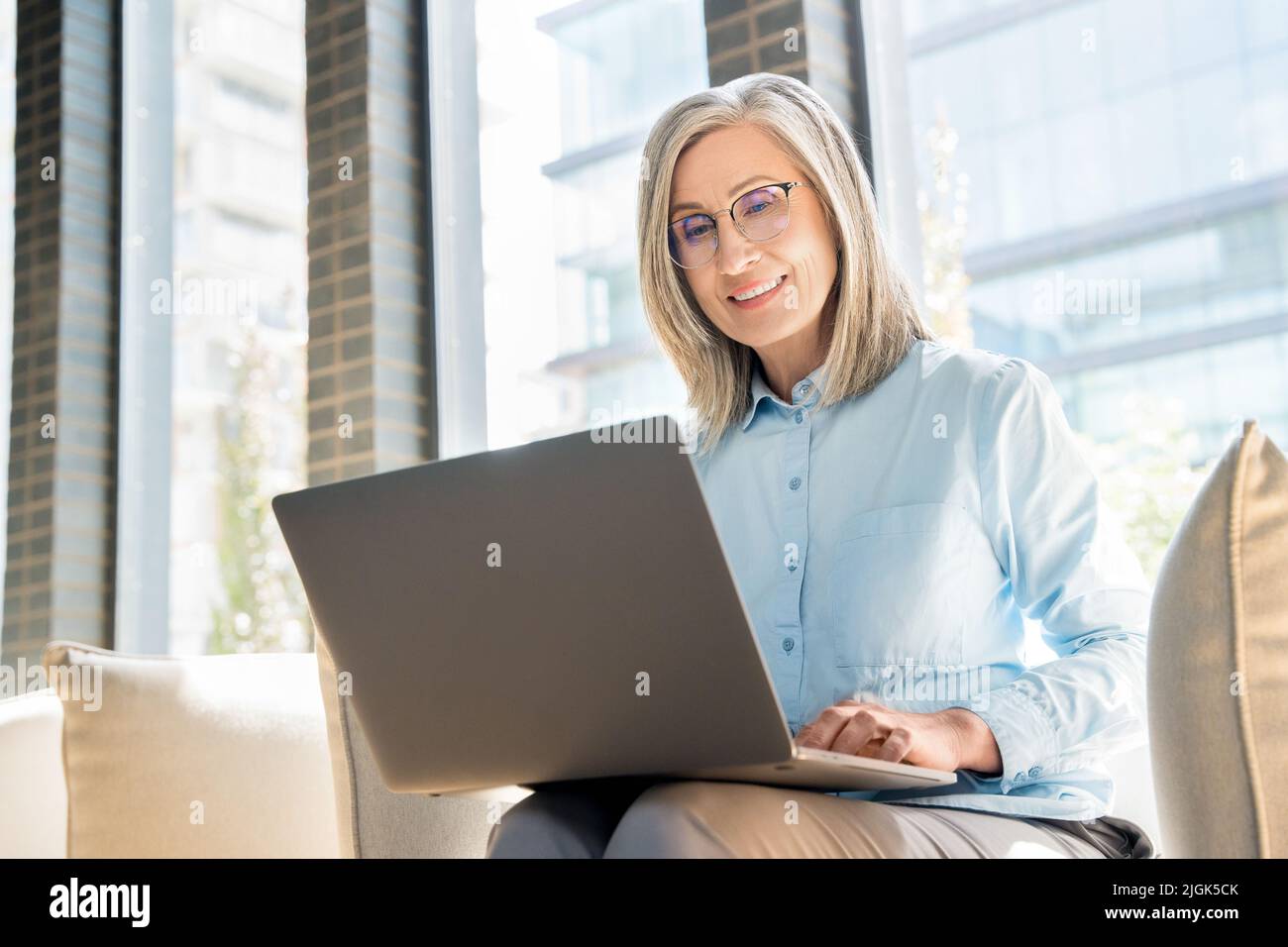 Ältere Frau arbeitet als Freiberuflerin am Laptop in einem Coworking. Stockfoto