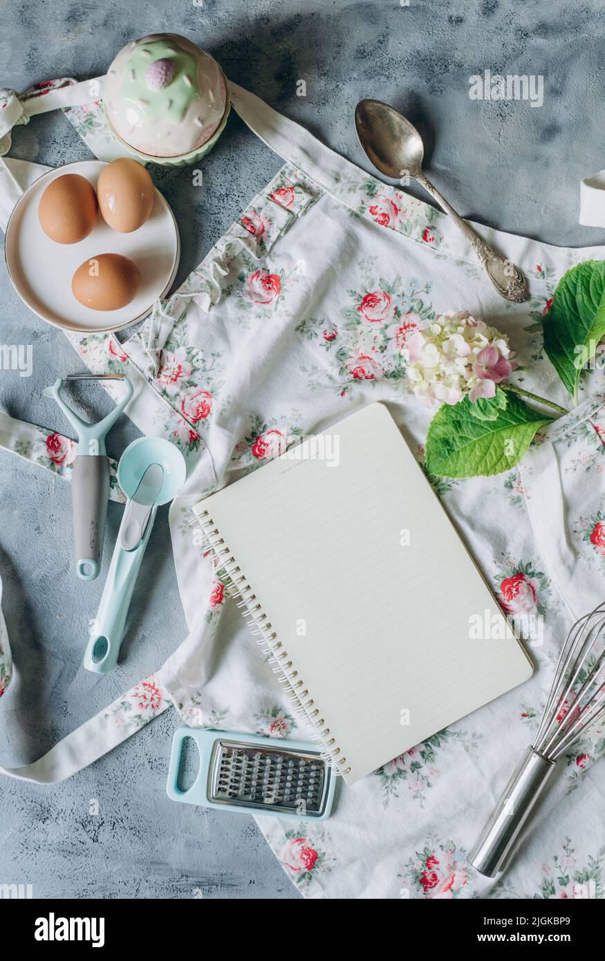 Rezeptbuch-Mockup auf Küchentisch mit Küchenutensilien im Vintage-Stil Stockfoto