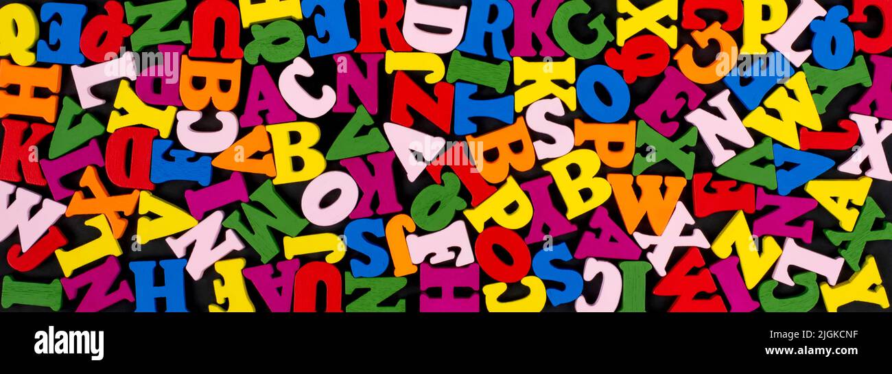 Bunte helle hölzerne Buchstaben auf schwarzem Banner Hintergrund. Zurück zum Schulkonzept. Stockfoto