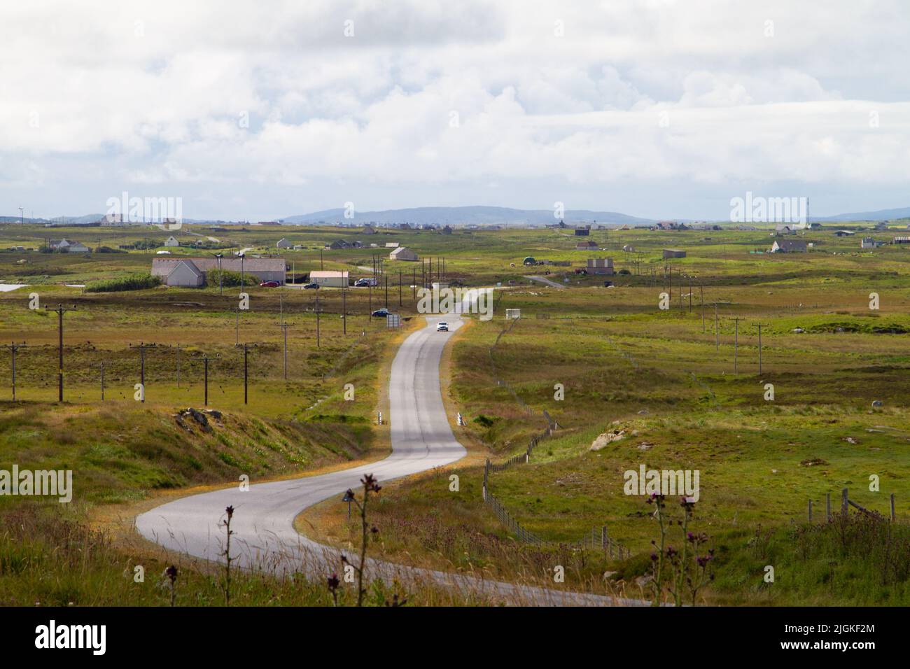 Ein Auto, das auf der A865 aus dem Süden von South Uist fährt. Blick vom Denkmal unserer Lieben Frau von den Inseln am Hang des Ruabhal Stockfoto