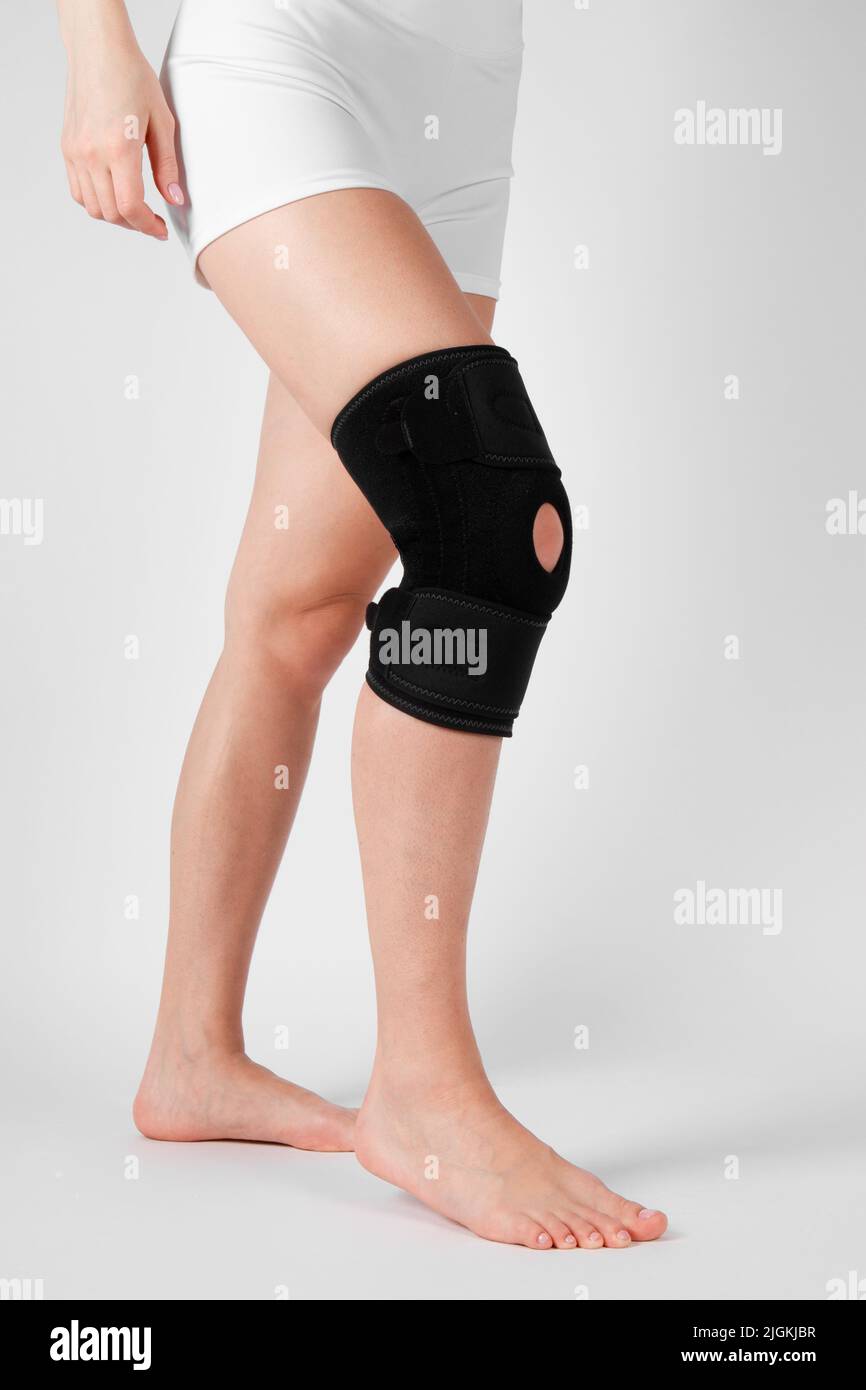 Kniestützenstrebe am Bein isoliert auf weißem Hintergrund. Elastische orthopädische Orthese. Anatomische Hosenträger für Kniefixierung, Verletzungen und Schmerzen. Schutz Stockfoto