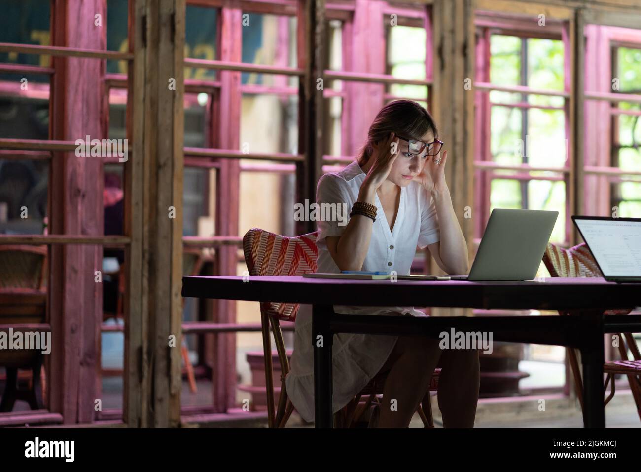 Müde oder gelangweilt kaukasische Arbeiterin oder Studentin sitzen am Schreibtisch brauchen Ruhe leiden an Müdigkeit Stockfoto