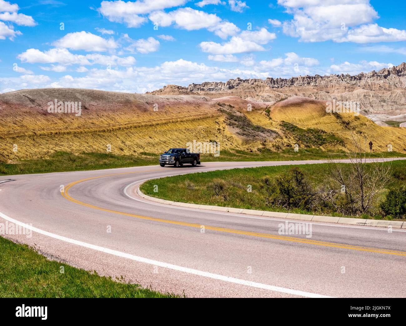 Fahrzeug auf der Badlands Loop Road im Gebiet der Yellow Mounds des Badlands National Park in South Dakota, USA Stockfoto