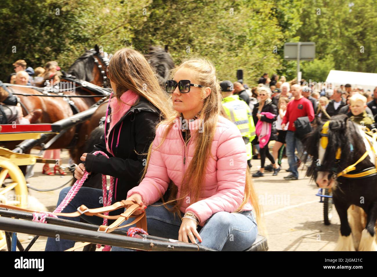 Zwei junge Reisende Mädchen, die in einem Pferd und einer Falle reiten. Appleby Horse Fair, Appleby in Westmorland, Cumbria, England, Vereinigtes Königreich Stockfoto