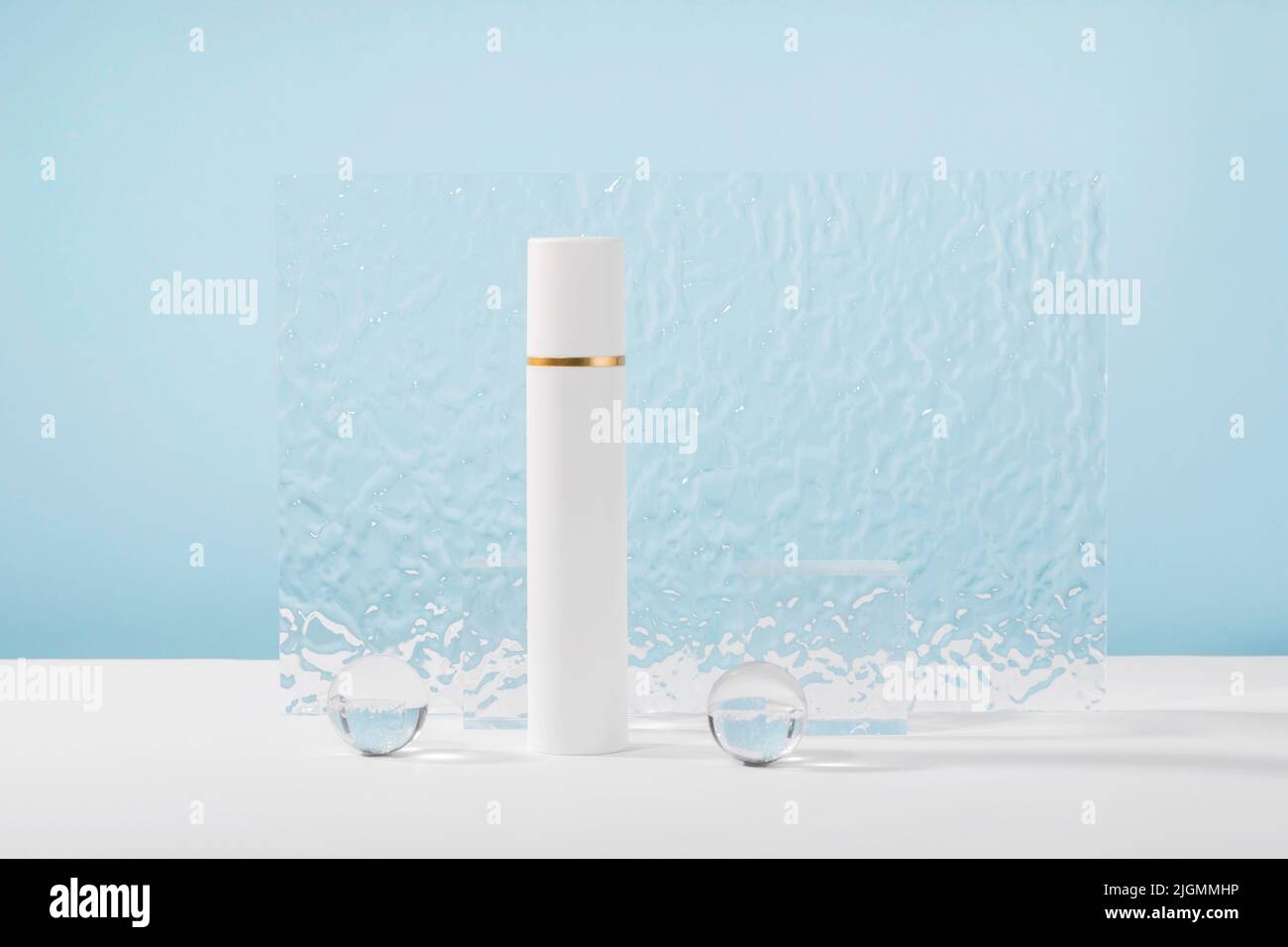 Unbranded kosmetische Creme Plastikröhrchen Mockup auf blauem Hintergrund mit stilvollen Requisiten, Glaskugeln und Acrylplatte. Lotion, Concealer oder weiße Schönheit Stockfoto