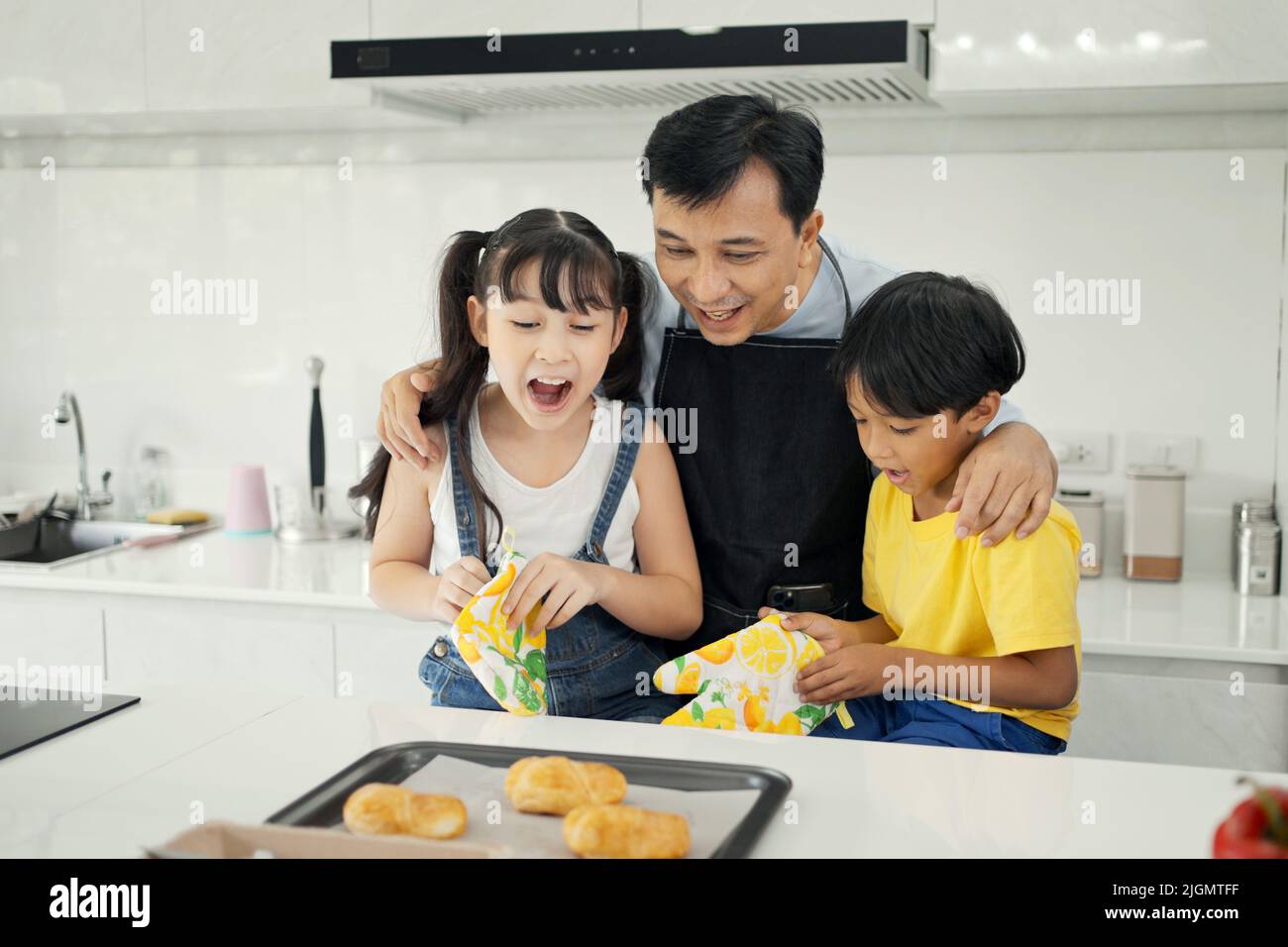 Glückliche asiatische Familie genießen Sie spielen und kochen in der Küche zu Hause. Stockfoto