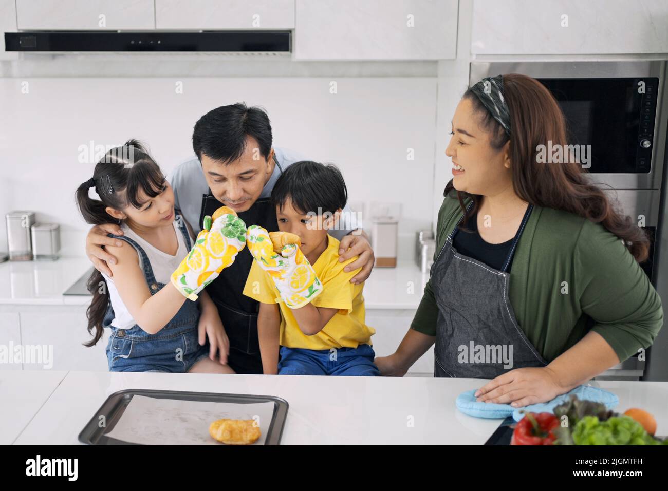 Glückliche asiatische Familie genießen Sie spielen und kochen in der Küche zu Hause. Stockfoto