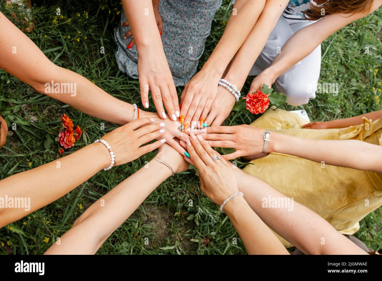 Weibliche Models, die die Hände in einem Kreis verbinden. Teamarbeit Stockfoto