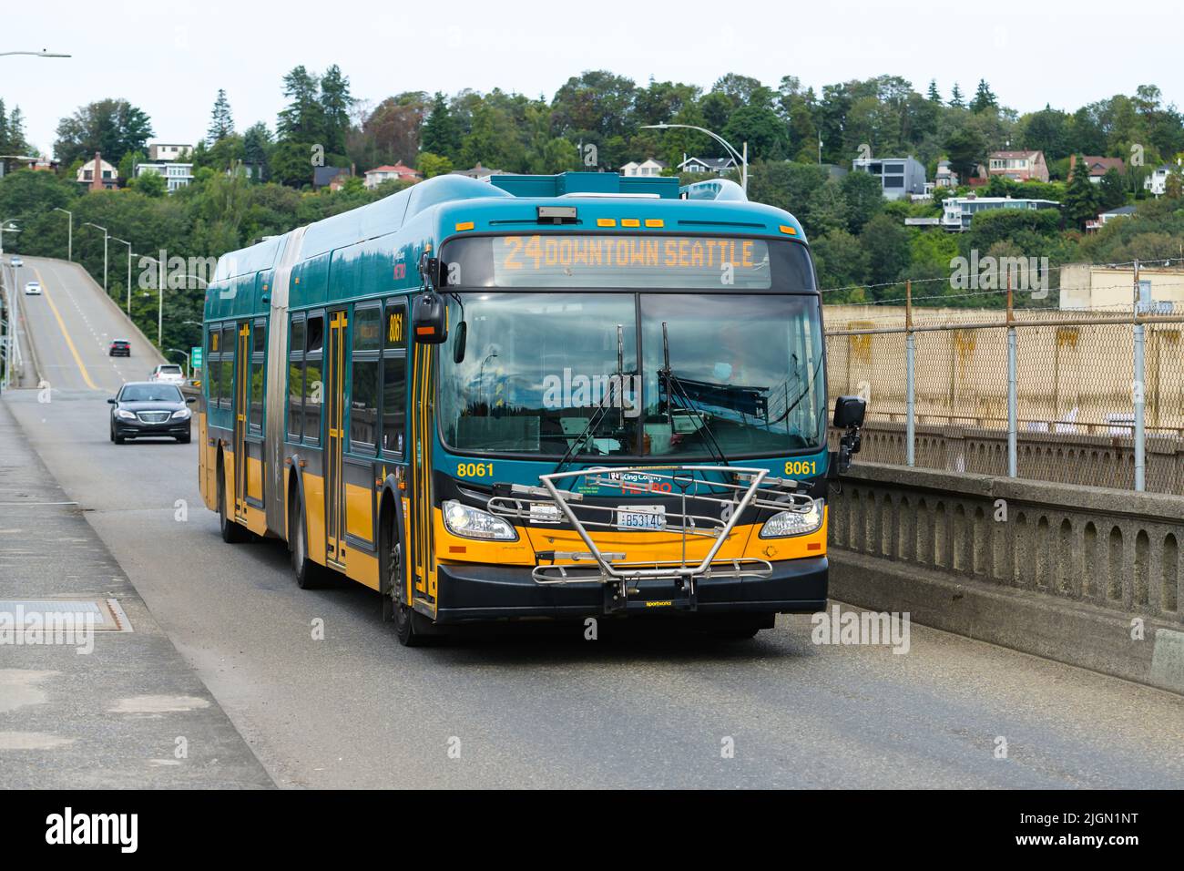 Seattle - 09. Juli 2022; türkisfarbener und orangefarbener dreitüriger King County Metro-Bus, der die Magnolia Bridge in Seattle überquert Stockfoto