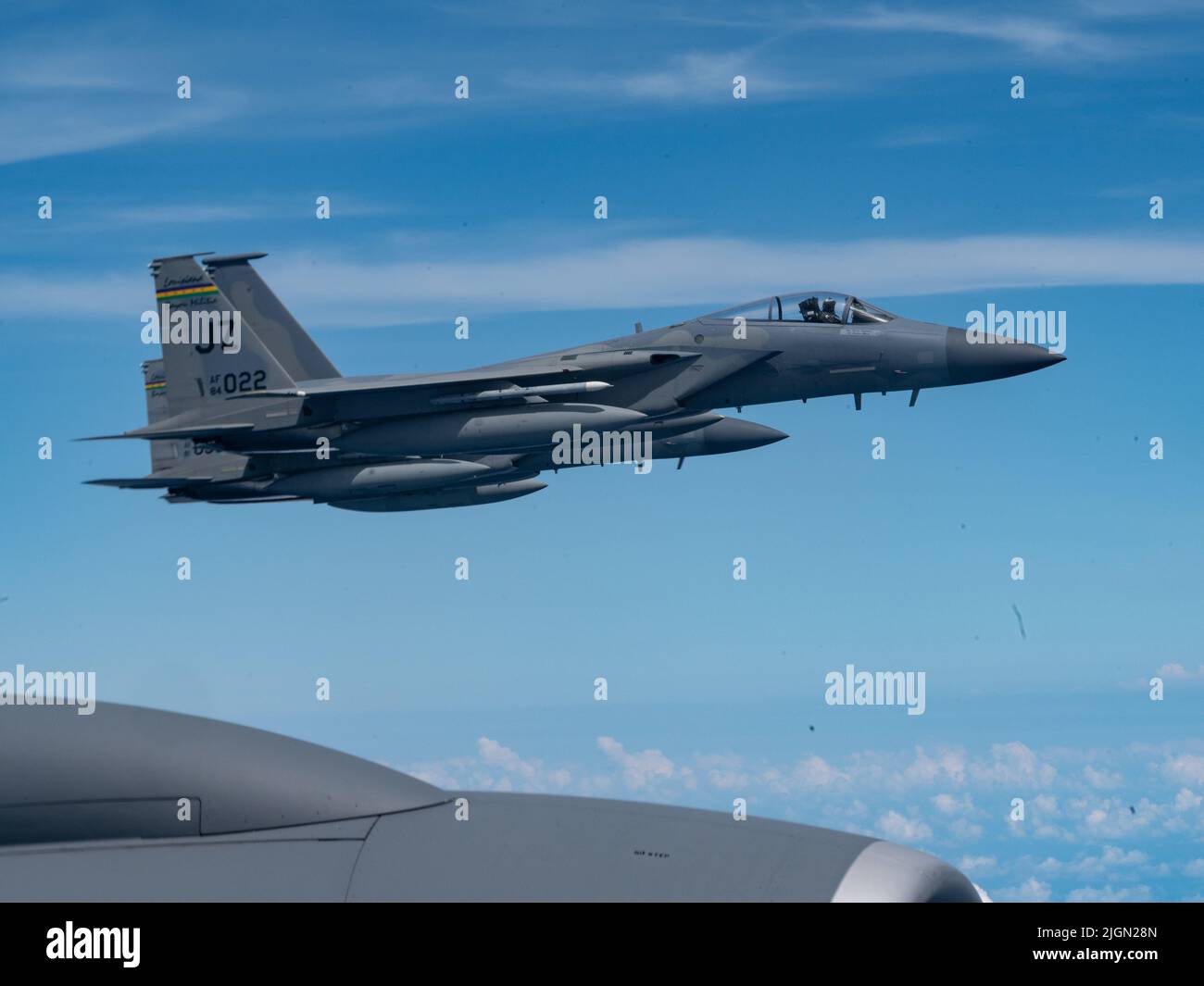 F-15 Adler fliegen mit dem 159. Fighter Wing, Louisiana, über den Flügel eines KC-135 Stratotankers mit dem 914. Air Betanking Wing Wing, New York, 10. Juli 2022 über den Südosten der Vereinigten Staaten. Die FW 159. trägt den Spitznamen „Bayou-Miliz“, die auf dem Schwanz der F-15 zu sehen ist. (USA Luftwaffe Foto von Tiffany A. Emery) Stockfoto