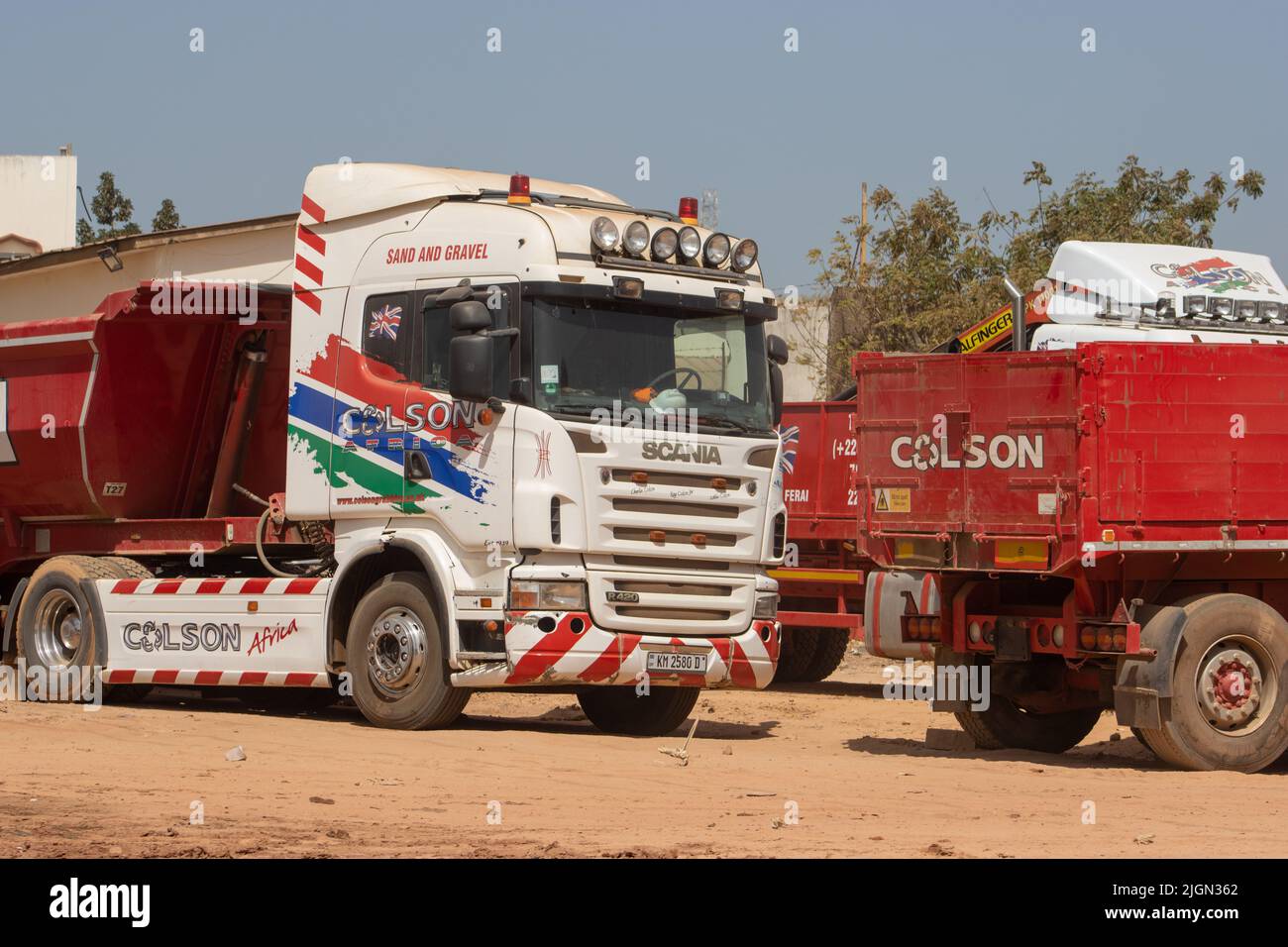 SERRAKUNDA, GAMBIA - 7. FEBRUAR 2022 LKW auf der Bertil Harding Autobahn mit Baumaterial zum Verkauf - Colson Sand und Kies geparkt Stockfoto