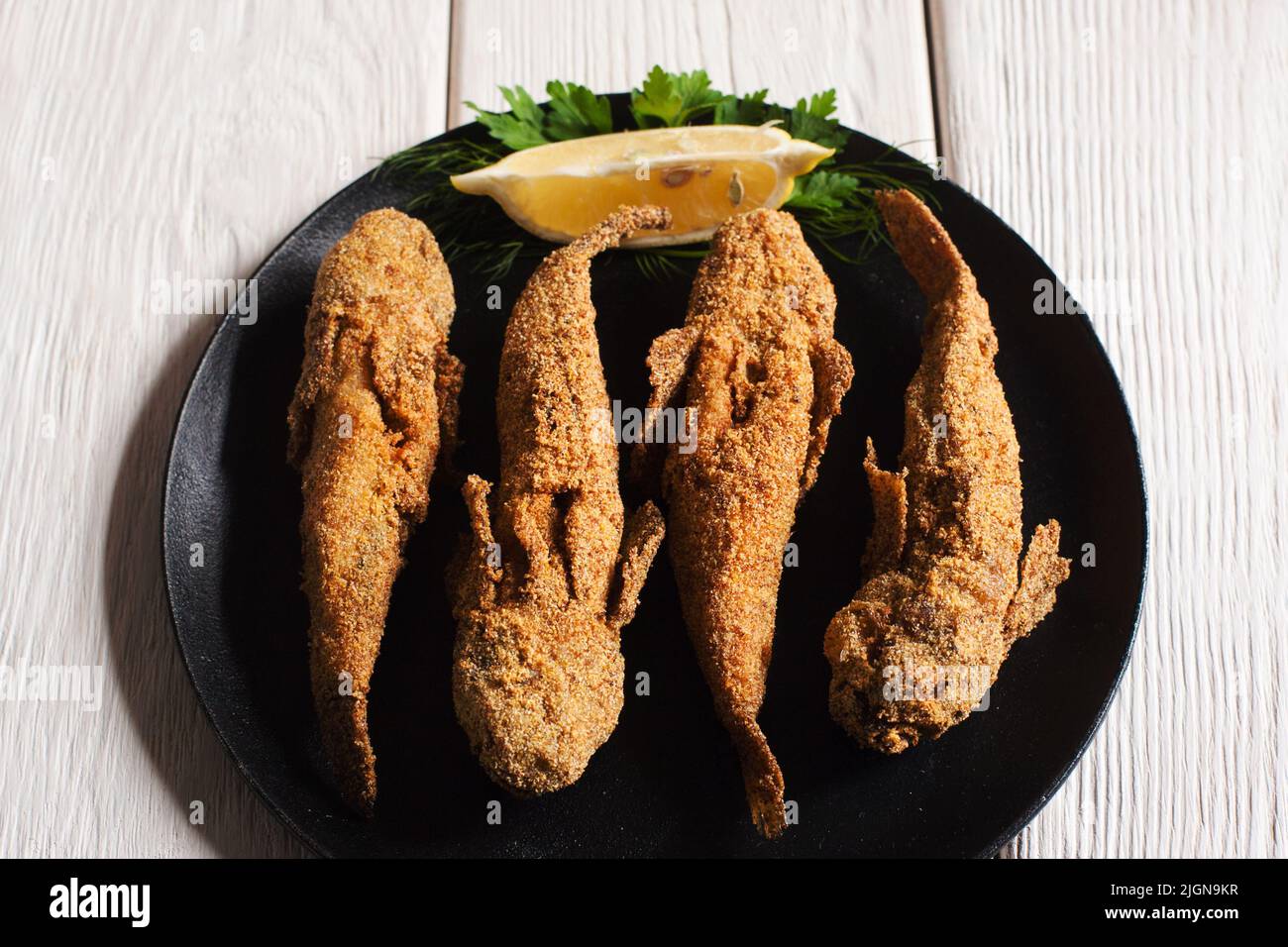 Leckerer frittierter Fisch auf schwarzem Teller, Draufsicht Stockfoto