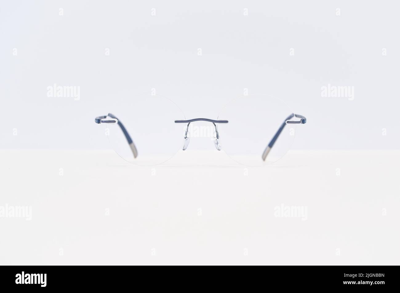 Rahmenlose Brillen auf einem weißen Schreibtisch mit Kopierfläche - Vision Care Konzept Stockfoto