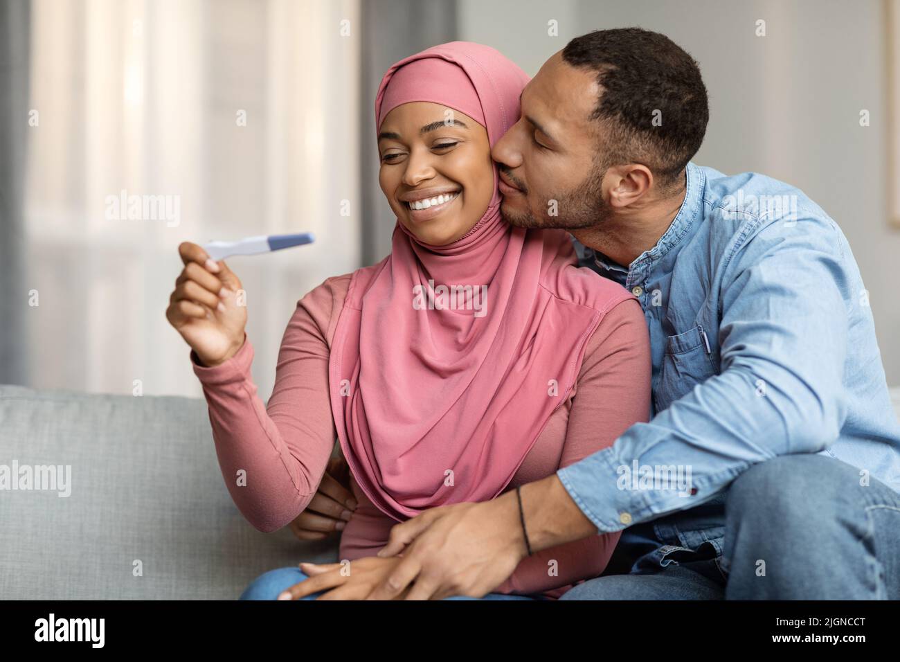 Eltern Werden. Porträt Von Schwarz-Muslimischen Ehegatten Mit Positivem Schwangerschaftstest Stockfoto