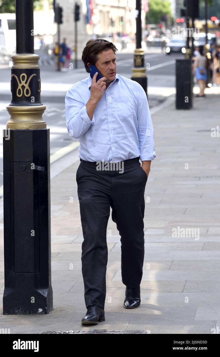 Johnny Mercer MP (Con: Plymouth Moor) - Minister für Veteranenangelegenheiten - auf seinem Mobiltelefon vor dem Kabinett in Whitehall, 11.. Juli 2022 Stockfoto