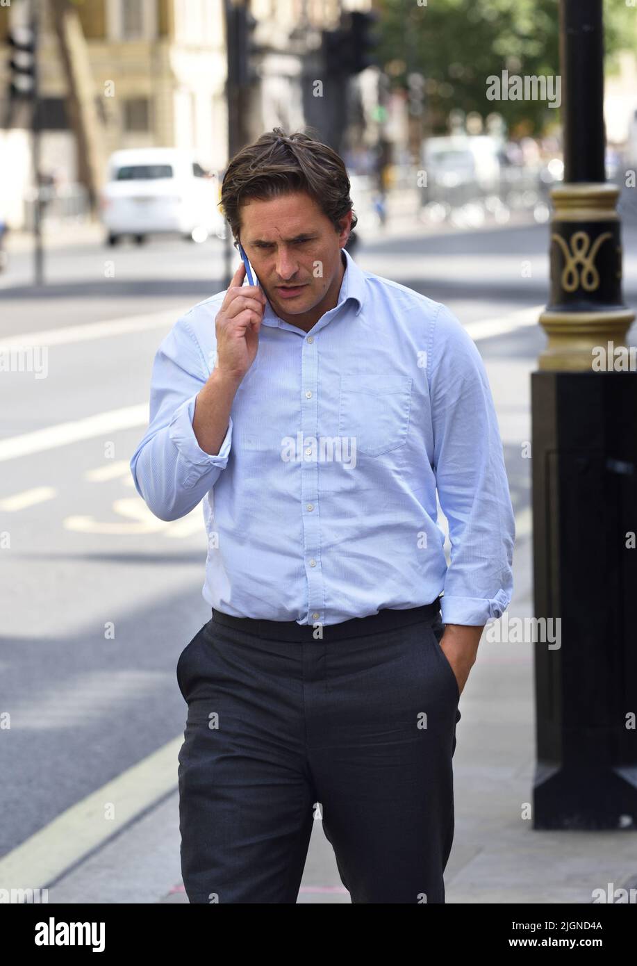 Johnny Mercer MP (Con: Plymouth Moor) - Minister für Veteranenangelegenheiten - auf seinem Mobiltelefon vor dem Kabinett in Whitehall, 11.. Juli 2022 Stockfoto