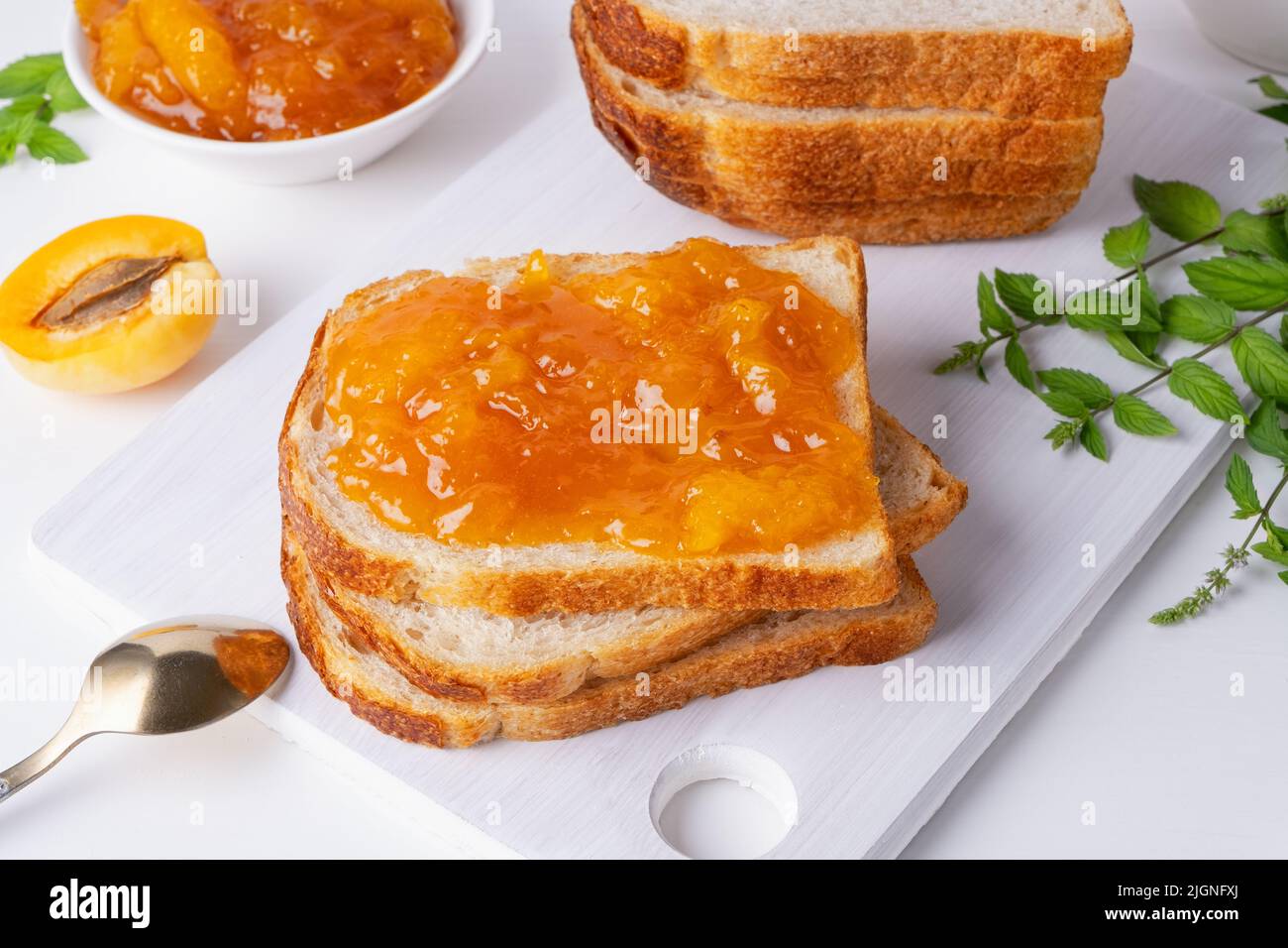 Toast mit Aprikosenmarmelade und frischen Früchten mit Minze Stockfoto