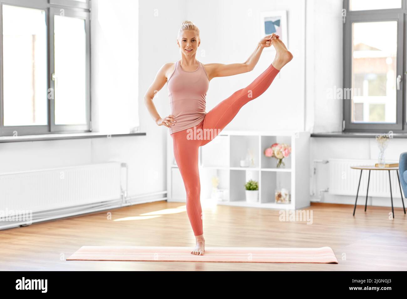 Frau, die zu Hause Yoga in einer Hand-bis-Fuß-Pose macht Stockfoto