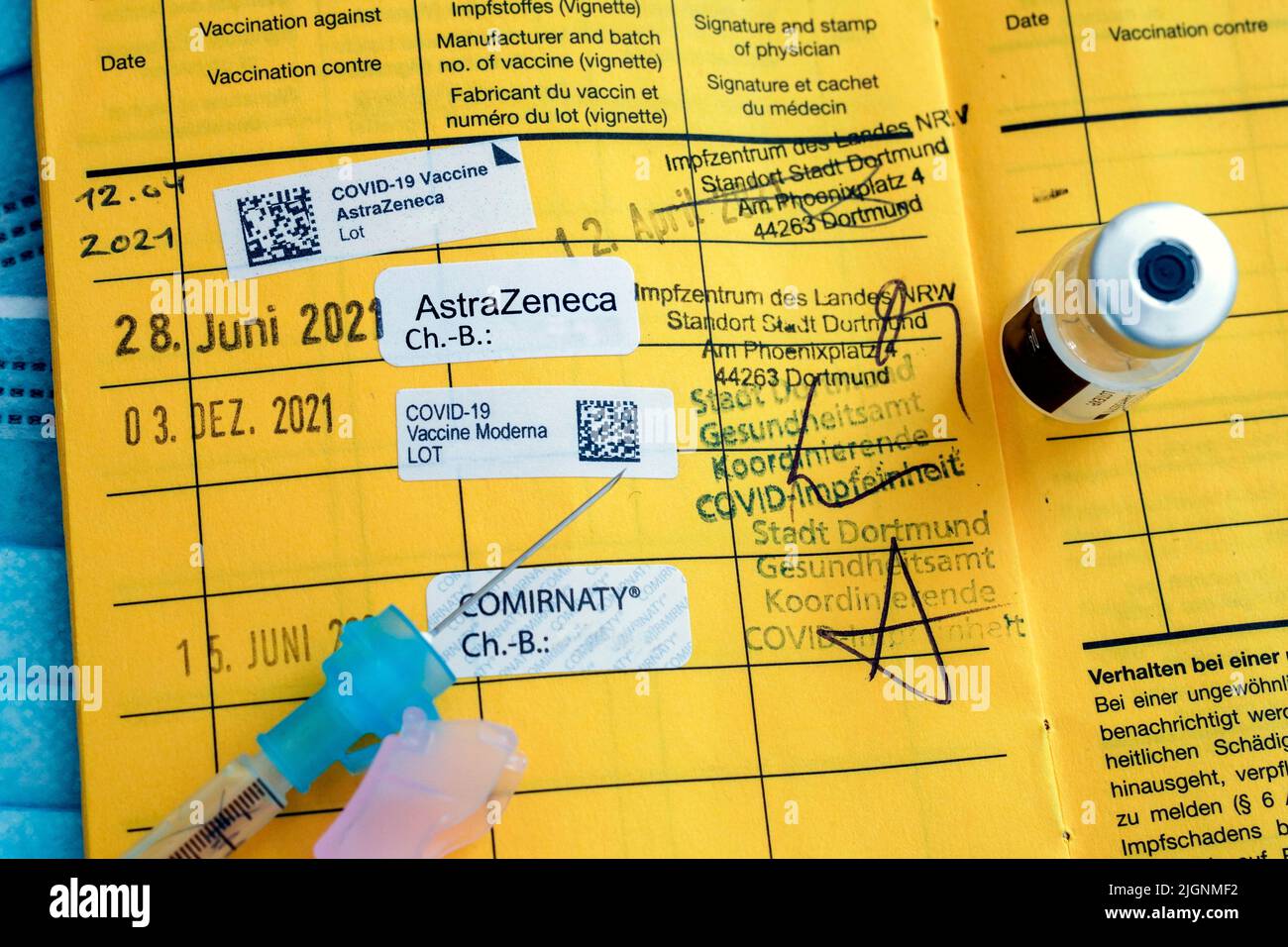 Spritze auf einer deutschen Impfkarte mit dem Vermerk von vier Impfungen gegen Covid-19, Auffrischungsimpfung - 07/12/2022 Stockfoto