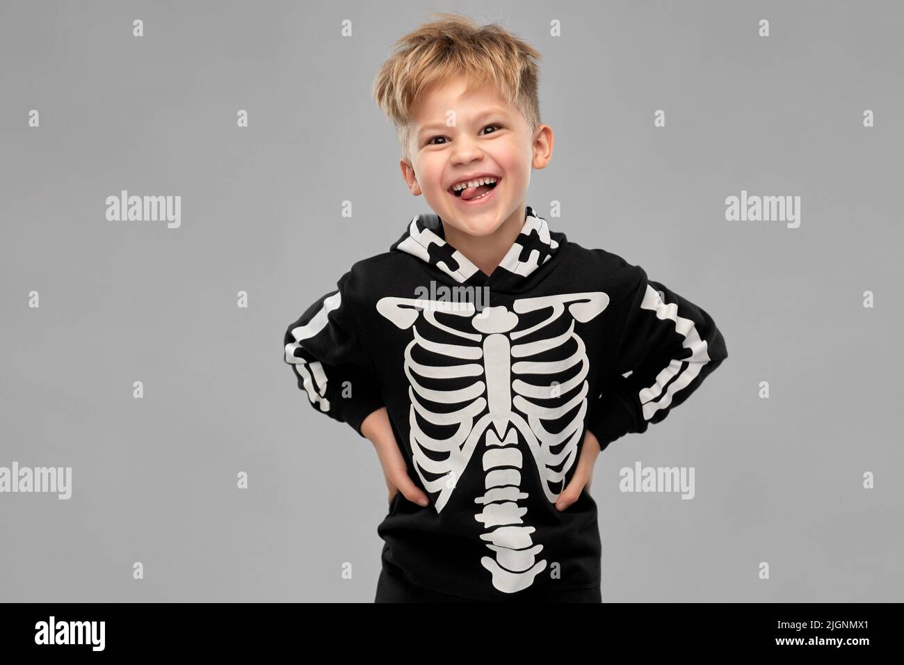 Junge im schwarzen halloween Kostüm mit Skelettknochen Stockfoto