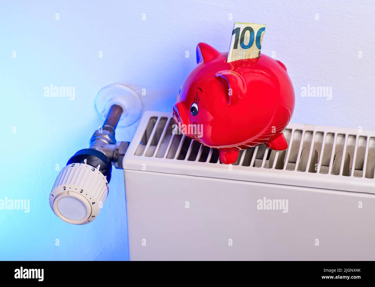 Sparen beim Heizen: Heizkörper und Thermostat mit Sparschwein und Geld Stockfoto