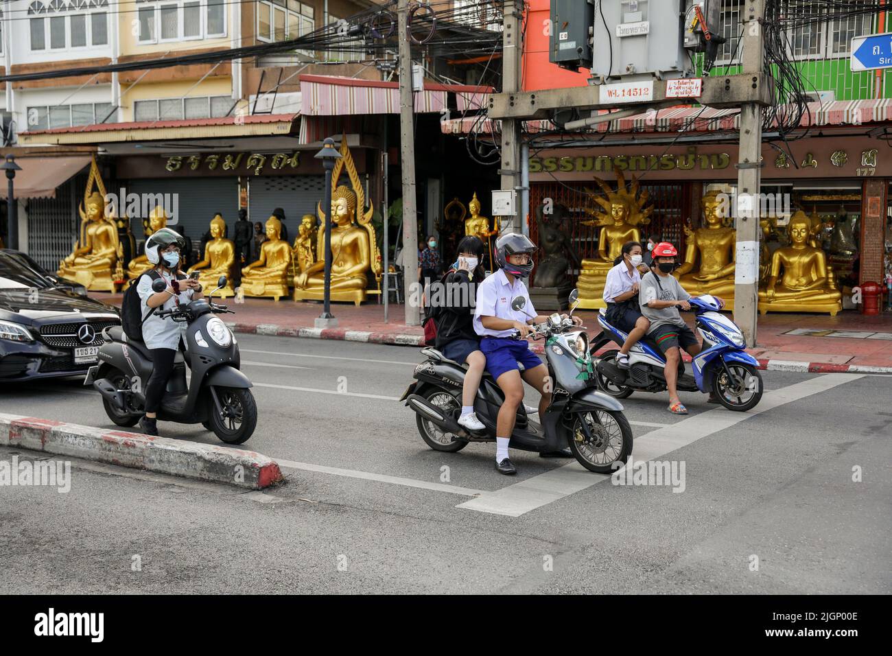Autofahrer kommen an Buddha-Statuen entlang einer Straße im Inneren des Großen Palastes in Bangkok vorbei. Thailand setzt trotz einer globalen Pandemie und neuer Wellen von Coronavirus-Fällen die Beschränkungen fort, um seinen Tourismus zu fördern. Thailand. Stockfoto