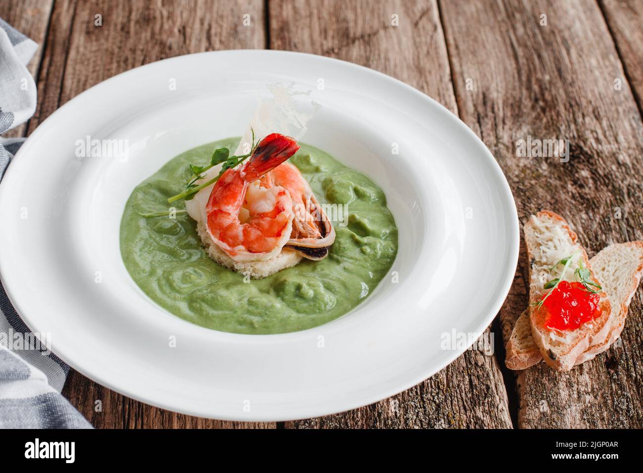 Cremesuppe aus Spinat mit Meeresfrüchten von oben Stockfoto