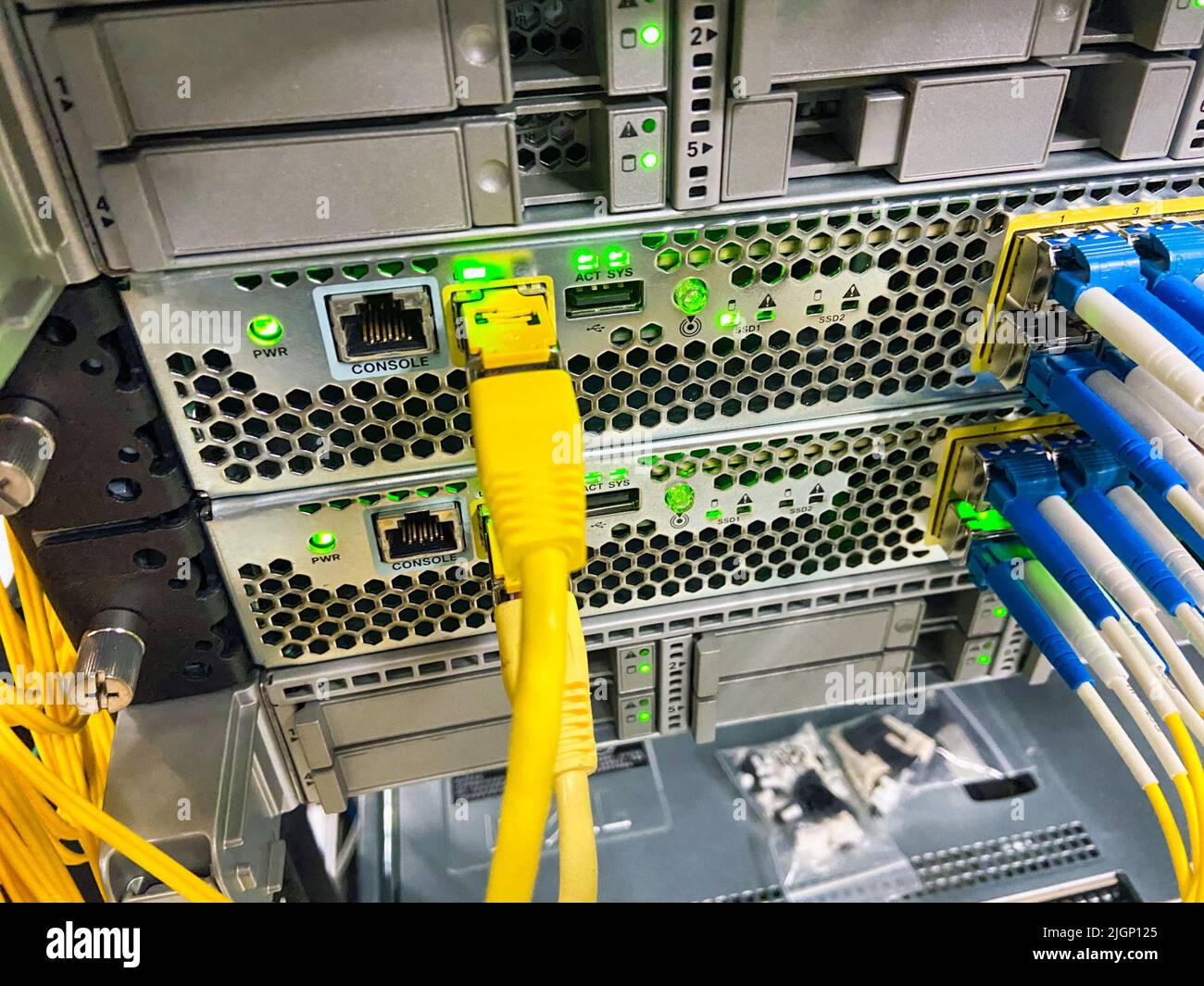 Netzwerkgeräte mit grünen Leuchten arbeiten in einem Rechenzentrum Stockfoto