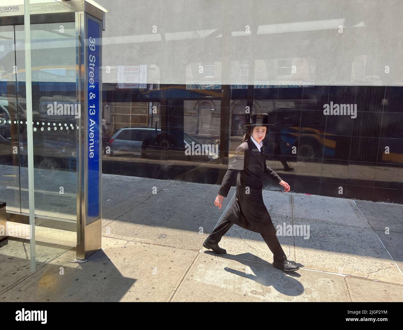 Junger orthodoxer jüdischer Mann geht entlang der 39. Street im Stadtteil Borough Park in Brooklyn, New York. Stockfoto