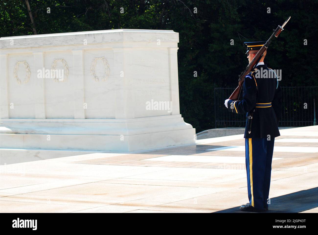 Ein Soldat steht zur Aufmerksamkeit und bewacht das Grab der unbekannten Soldaten auf dem Nationalfriedhof von Arlington in der Nähe von Washington DC Stockfoto