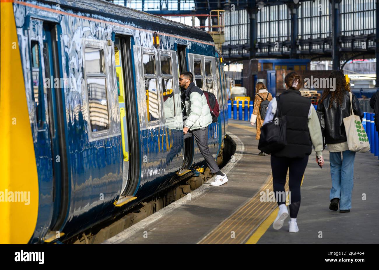 Passagiere, die in einem Zug der British Rail-Klasse 313 in der Southern Livery, Brighton Railway Station, England, einsteigen. Stockfoto