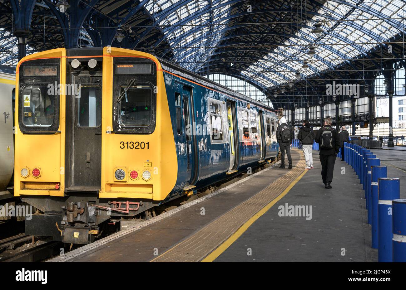 Passagiere, die in einem Zug der British Rail-Klasse 313 in der Southern Livery, Brighton Railway Station, England, einsteigen. Stockfoto